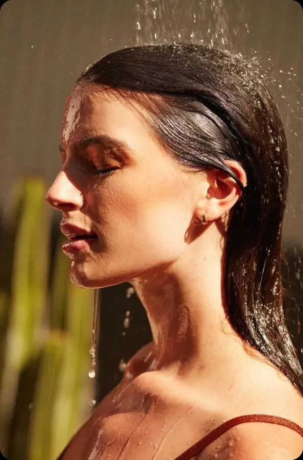 Woman rinsing her hair under filtered water